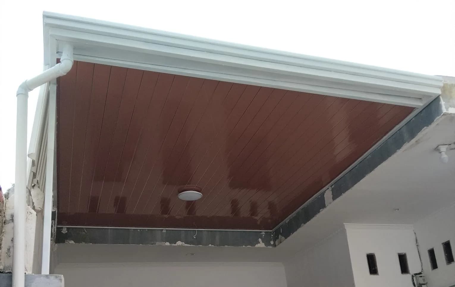 Tampak bawah plafon kanopi carport dengan rangka besi dan talang air rapi