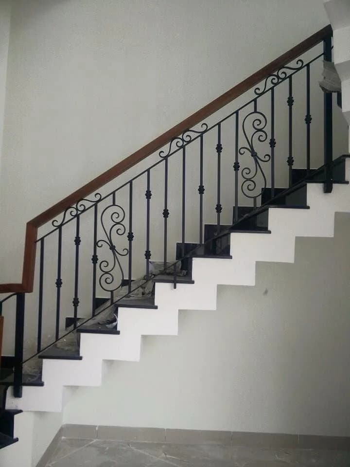 Railing tangga besi klasik dengan baluster motif scroll dan handrail kayu
